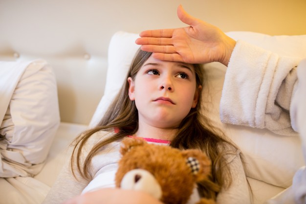 mother checking fever of her daughter in bedroom 1170 2752