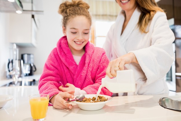 mother preparing breakfast for her daughter in kitchen 1170 2631