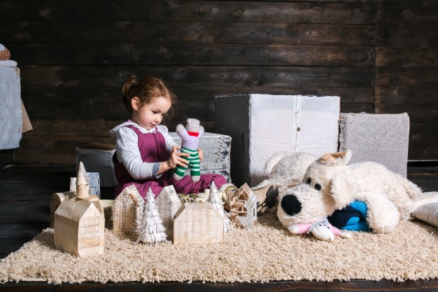 girl sitting on carpet playing with puppet 1153 2552